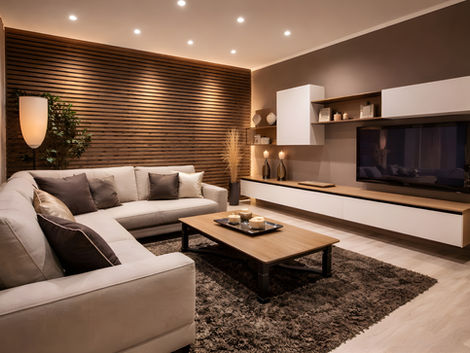 Modern living room with beige sofa, wood-slat wall, and TV unit
