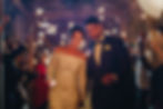 Bride and groom walk through a sparkler-lit exit, sharing a joyful and romantic wedding moment.
