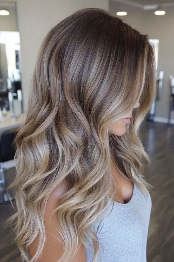 Soft lived-in colour melt blending blonde highlights with natural regrowth for effortless dimension created by The Edit Salon Adelaide.