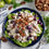 Thumbnail: Passion Infused Eatery's Summer Chicken Salad presented on a black plate, featuring a bed of lettuce topped with whole pecans and fresh whole grapes. The chicken salad is made with homemade mayo, finely diced onion, celery, and pecans, mixed well with shredded chicken chunks. The scene is set against a white tablecloth backdrop, with a bowl of whole pecans and a fork placed next to the plate. A delicious and visually appealing salad option bursting with flavor and texture contrasts. 