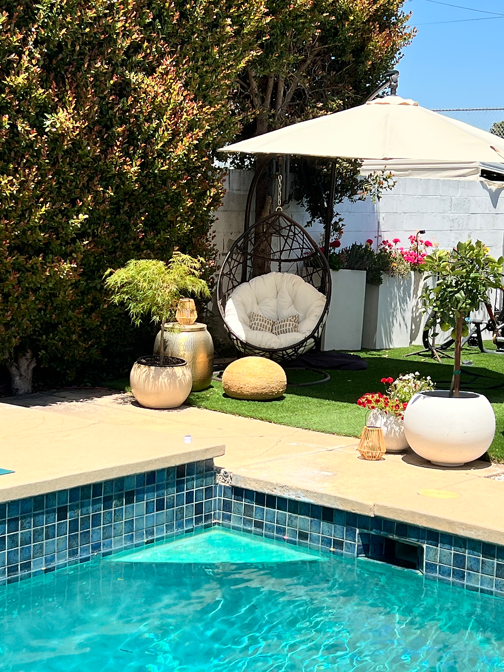 Restored Christopher Knight wicker egg chair poolside with cream cushion, gold planters and bougainvillea, Santa Monica backyard