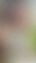 Female holding face looking into the camera wearing white halter dress with a beautiful assortment of tattoos