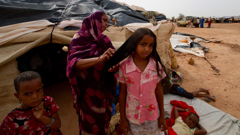 A mother brushes her daughter's hair, Mentao refugee camp, Burkina Faso, 2014