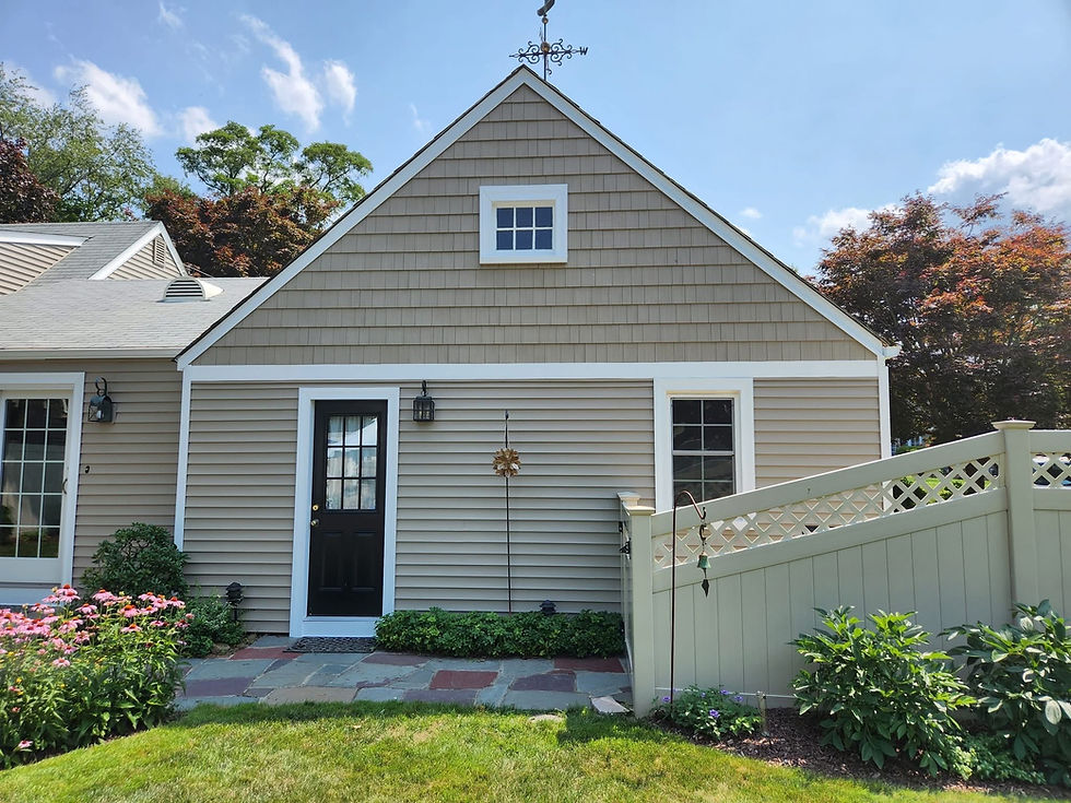 Residential exterior renovation featuring vinyl siding and new windows on Rhode Island home