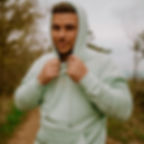 Mann trägt otkuthuer Kapuzie und schaut in die Kamera