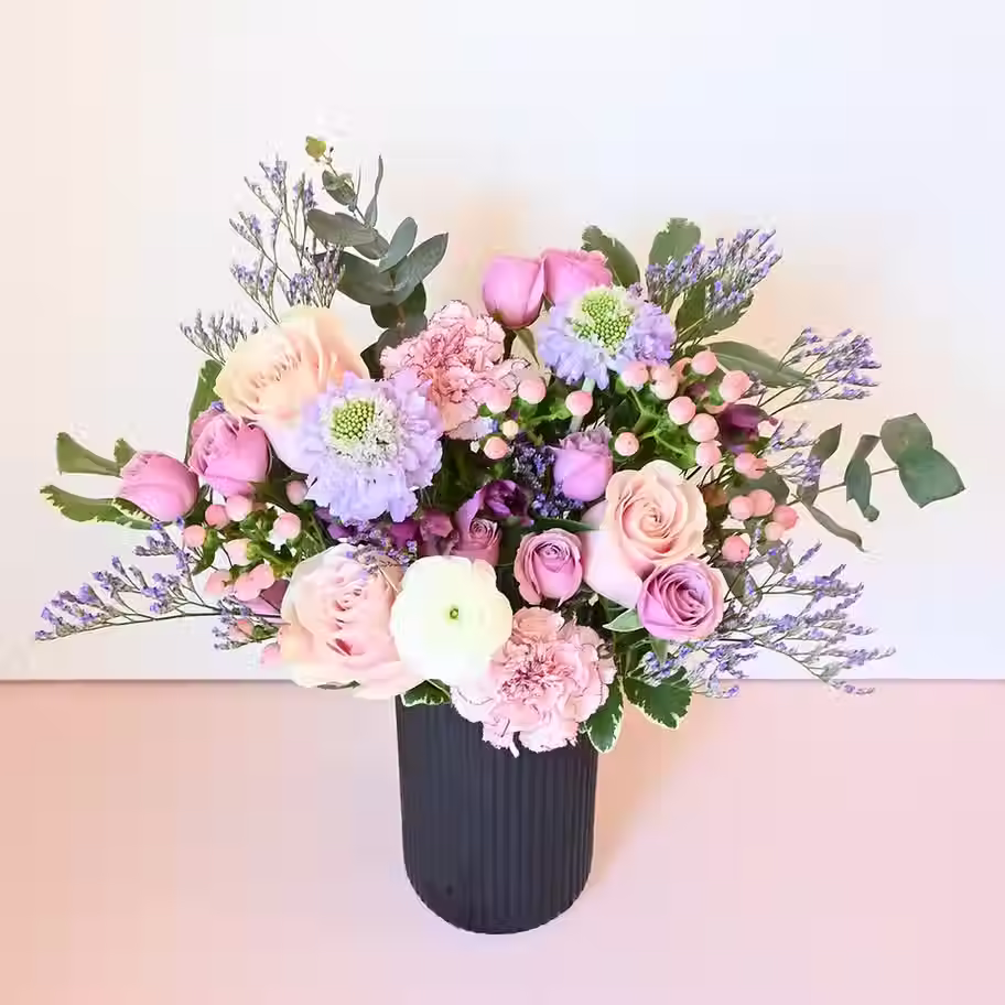 Elegant pastel flower arrangement in a black vase