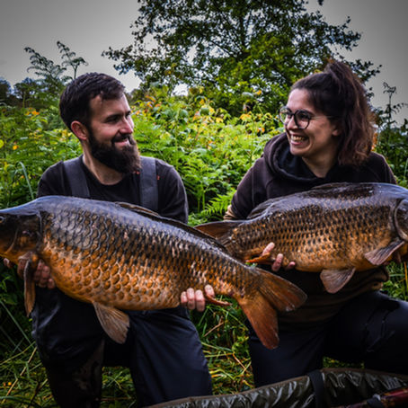 Deux pêcheurs souriants présentent chacun une carpe commune capturée en petite rivière sauvage, illustrant une pêche mobile, simple et respectueuse en milieu étroit.