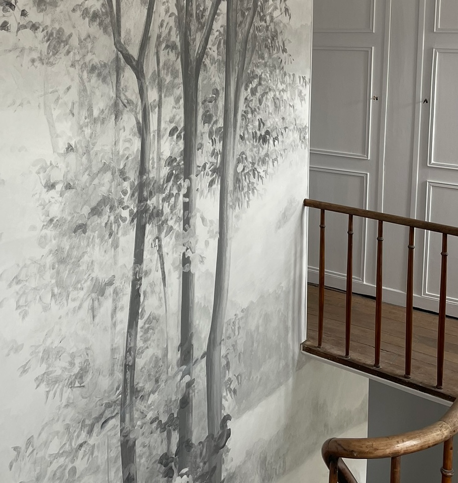 The tall trees of wallpaper by Les Dominotiers appear to grow from the ground floor upwards.