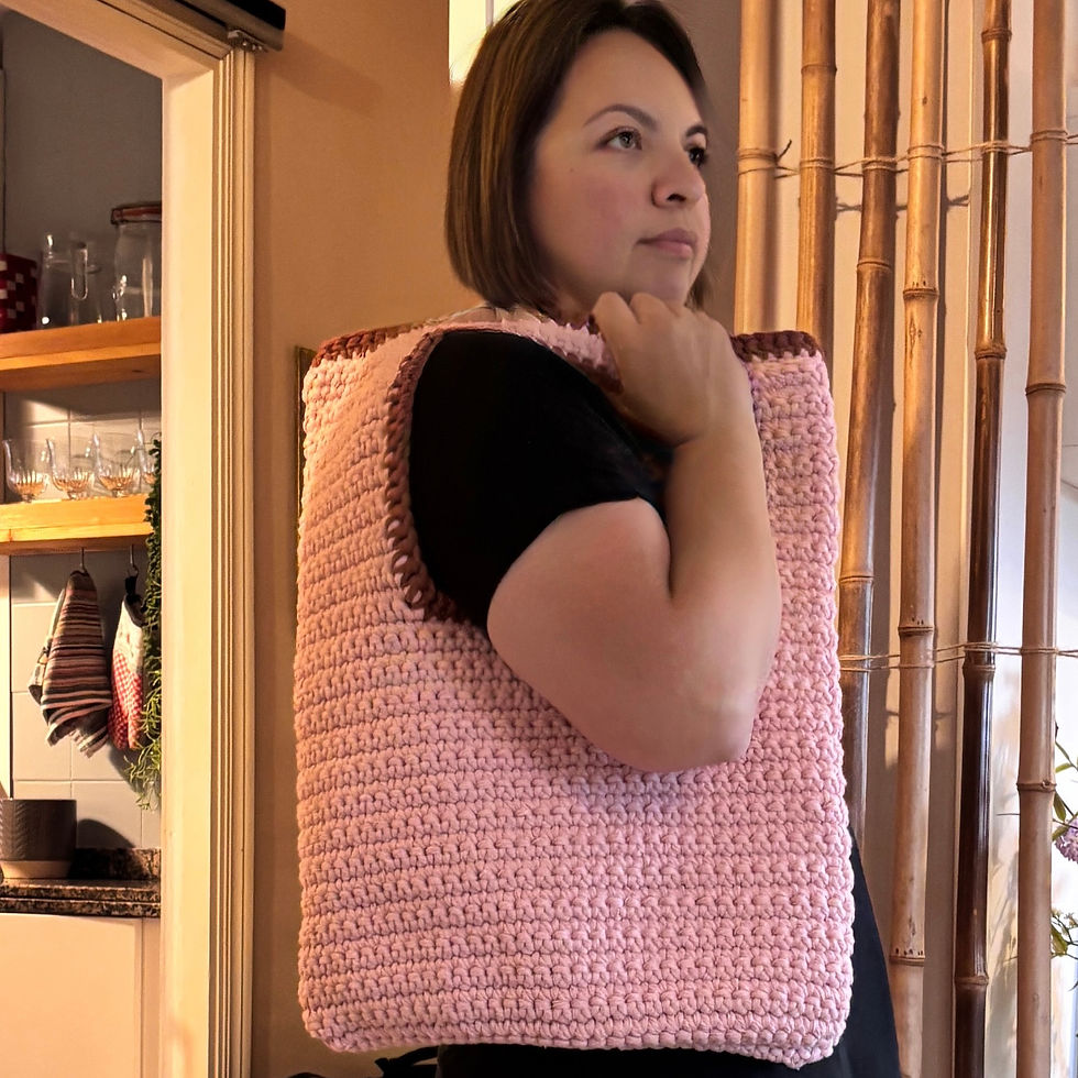 Sabbatical nemen: een zelf gehaakte tas van macrame in roze met bruine details aan de randen. 