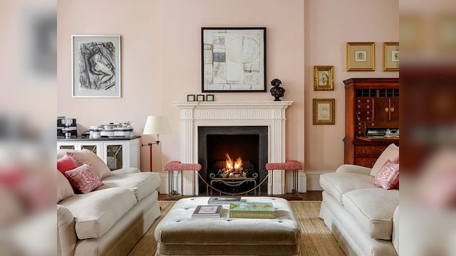 Living room interior with fireplace, paintings, sofas, and decorative furniture for relaxing.