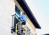 Window installer outside a window opening on scaffolding