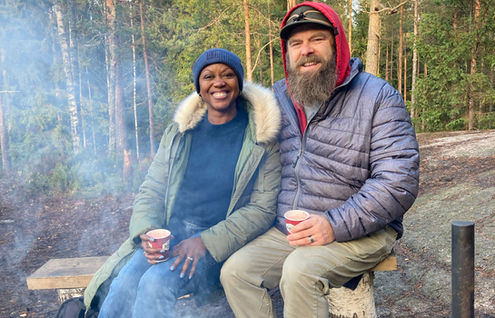 couple sitting by fireplace in a national park nearby Helsinki