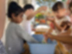 Kindergarten students exploring water and materials together in a hands-on outdoor activity