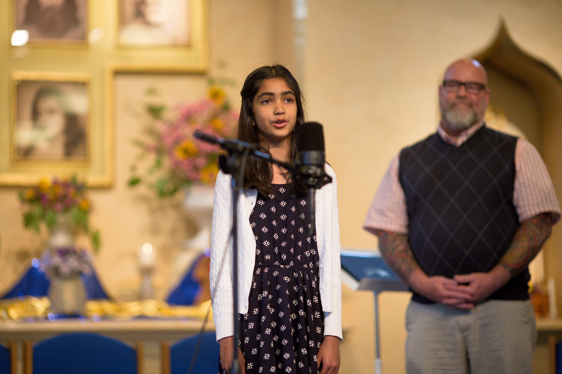 Student speaking at a microphone during a school presentation at Living Wisdom School in Palo Alto
