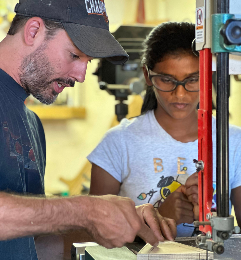 Teacher guiding a student during a woodworking class