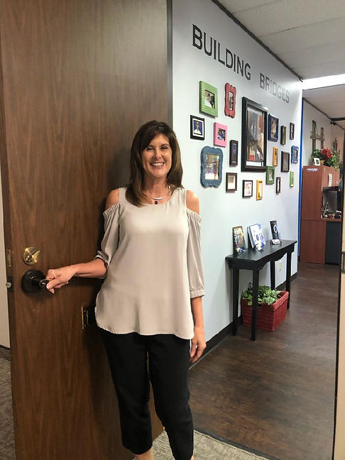 Teresa at entrance door of Bridge Builder Academy school