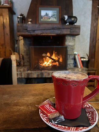 Un chocolat chaud sur une table rustique dans un chalet d'alpage devant un bon feu