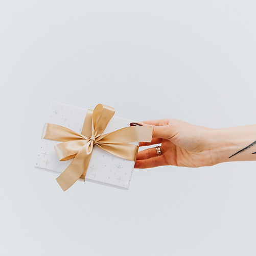 tattooed hand holding out present.png