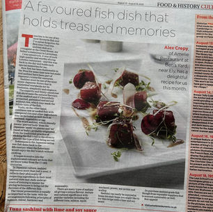 Newspaper page titled Cambridge Independent, featuring a fish dish recipe with text about tuna sashimi. Emphasizes culinary traditions.