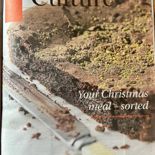 Close-up of a chocolate cake topped with green pistachios, on a magazine page titled "Culture". Text reads "Your Christmas meal – sorted".