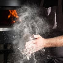 clapping hands with a cloud of four around in front of a pizza oven
