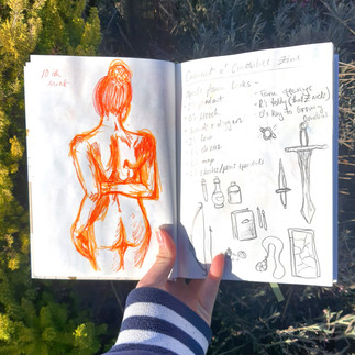 sketchbook spread of a figure drawing and objects