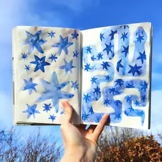 sketchbook spread of a blue snake and stars