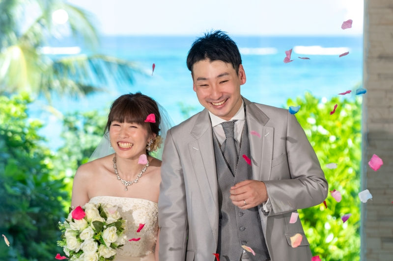 沖縄恩納村のムーンビーチでフォトウエディング。青い海を見渡せるチャペルフォトで、フラワーシャワーによる笑顔の退場シーン。