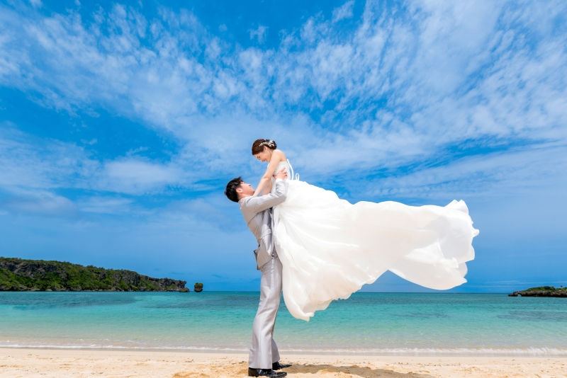 沖縄恩納村でのビーチフォト。高々と新婦を抱き上げるリフトショットは、幸せなフォトウエディングの一枚に。