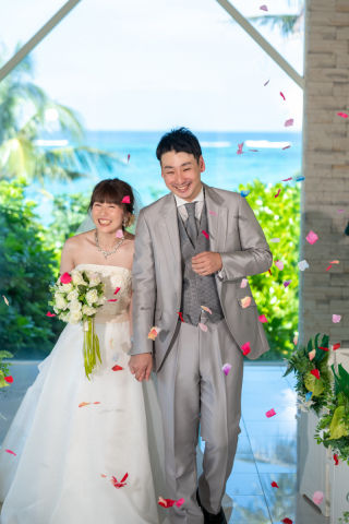 沖縄恩納村のムーンビーチでのチャペルフォト。結婚式のようなフォトウエディングで、フラワーシャワーによるチャペル退場シーンは幸せいっぱいの表情。