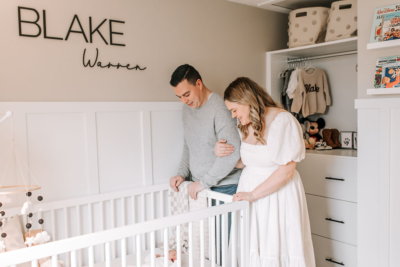 Mom and dad looking over nursery crib