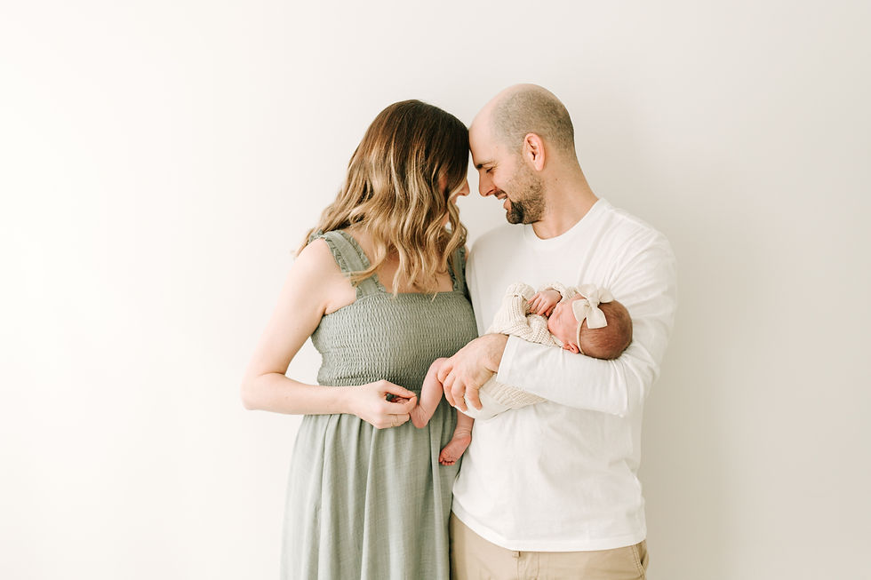 Parents holding their newborn baby during a newborn photography session in Guelph, Ontario