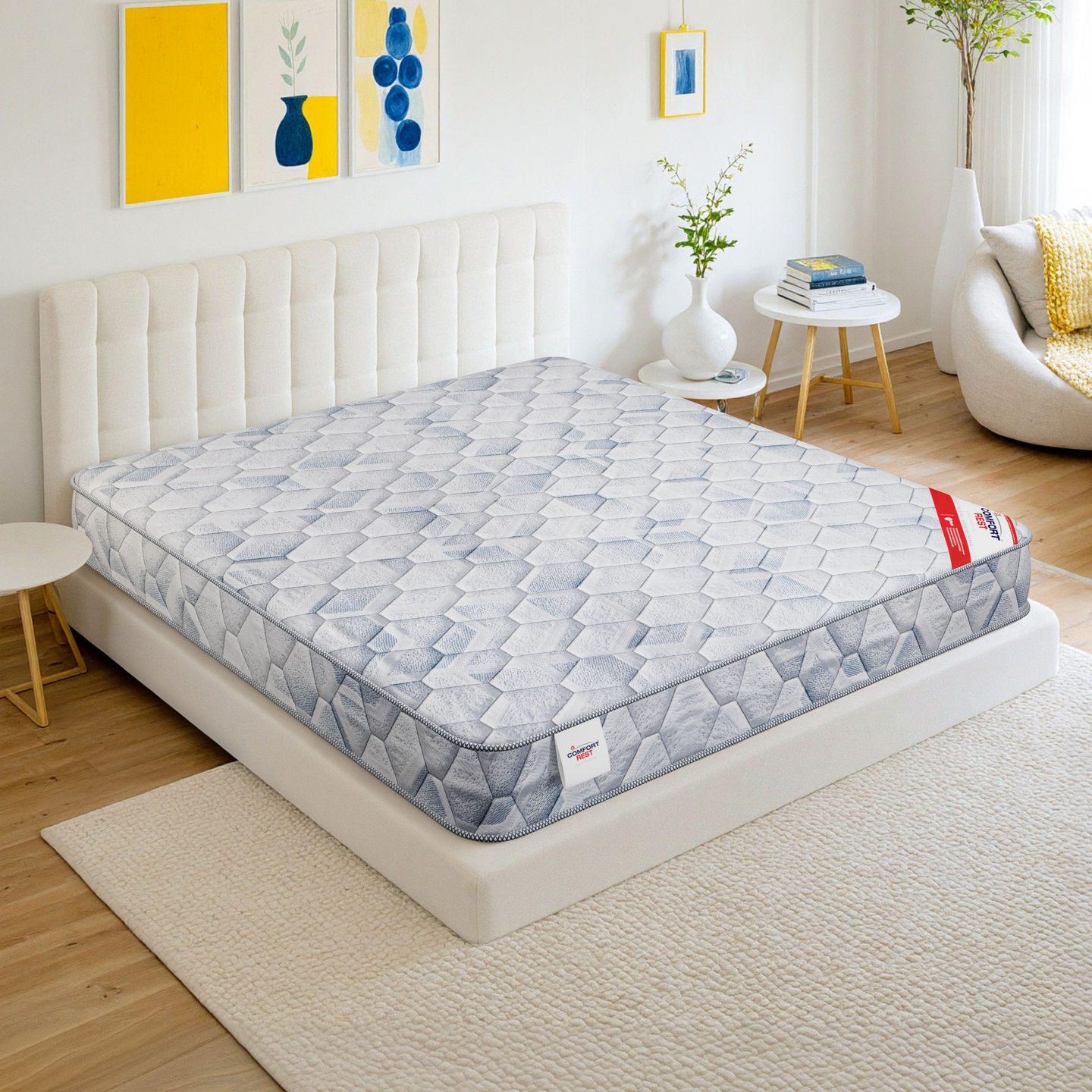 White mattress with a gray border, bed, and decorative art in a bedroom setting.