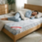 Woman sleeping on a bed, with a pillow, comforter, and comfortable mattress.