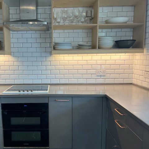Custom kitchen designed and built by Valchromatic made from grey valchromat and plywood, with ample storage, and worktop space, and shelving 