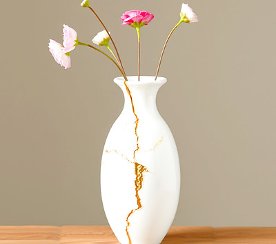 a white vase with gold mending the broke