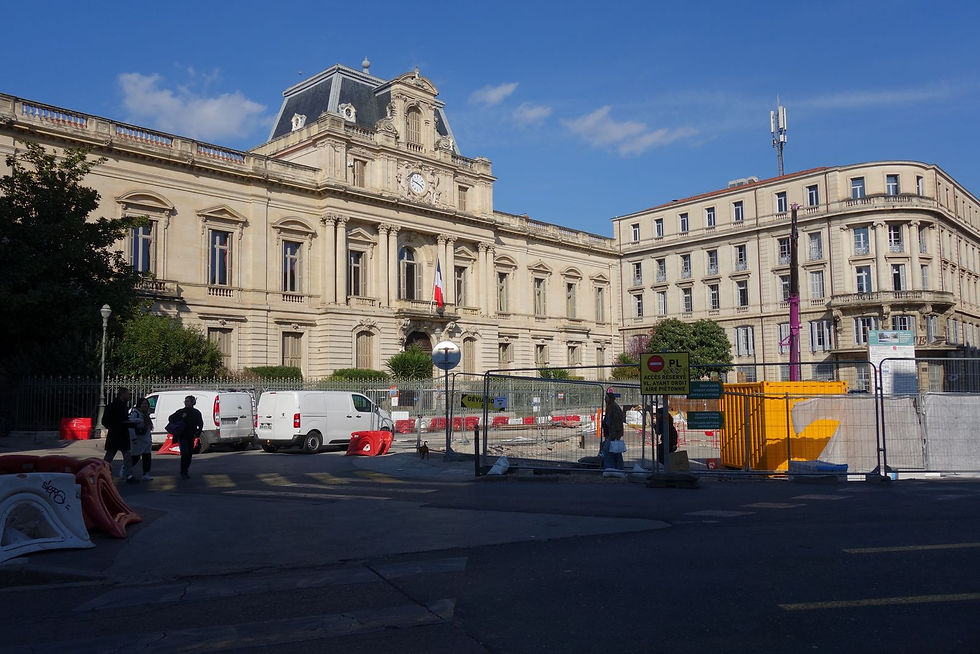 A plaza blocked off by fencing surrounded by Renaissance era French buildings.