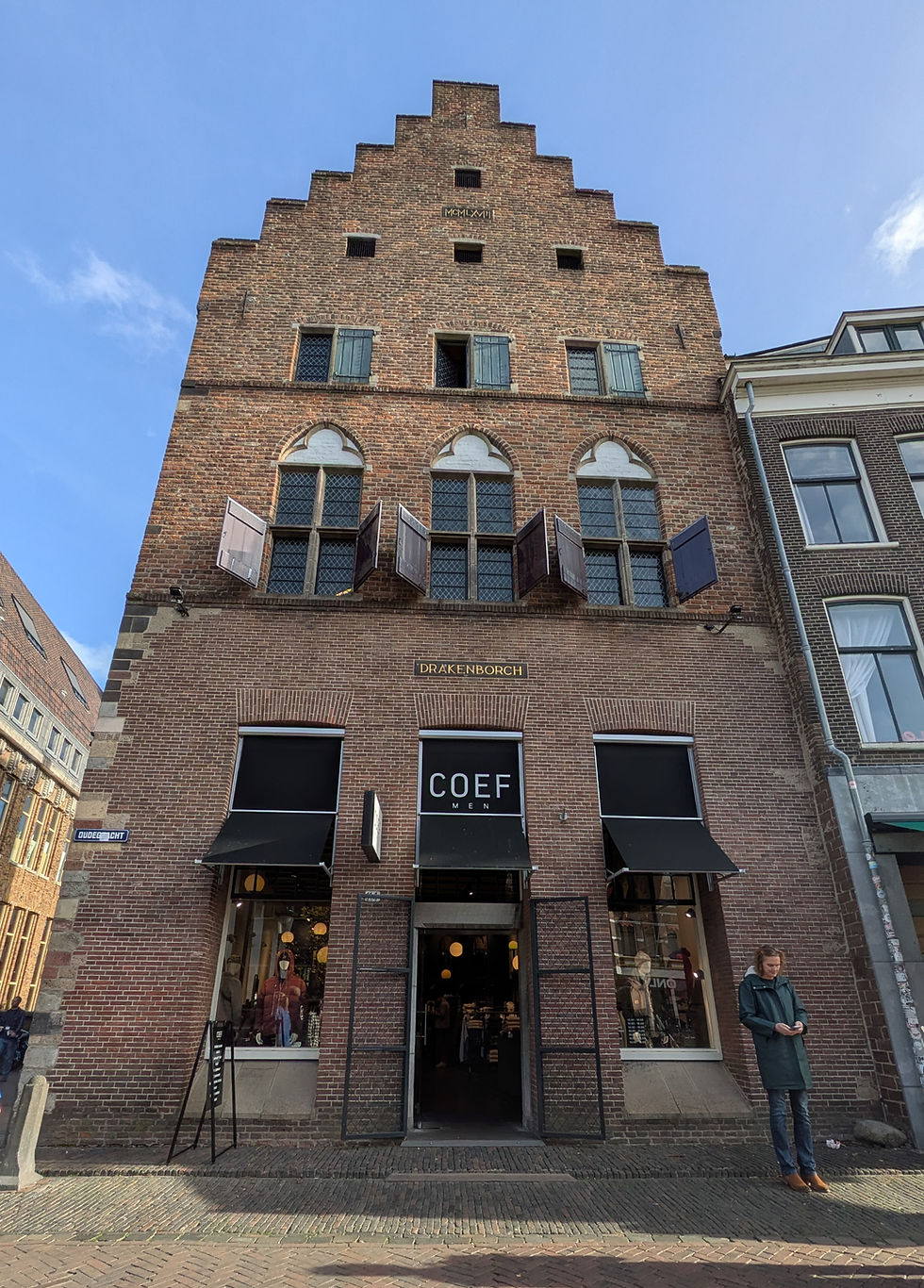 An old, red brick, stepped gabled Dutch building of five stories, topped with a one-window attic. The ground floor is now a clothing boutique named Coef.