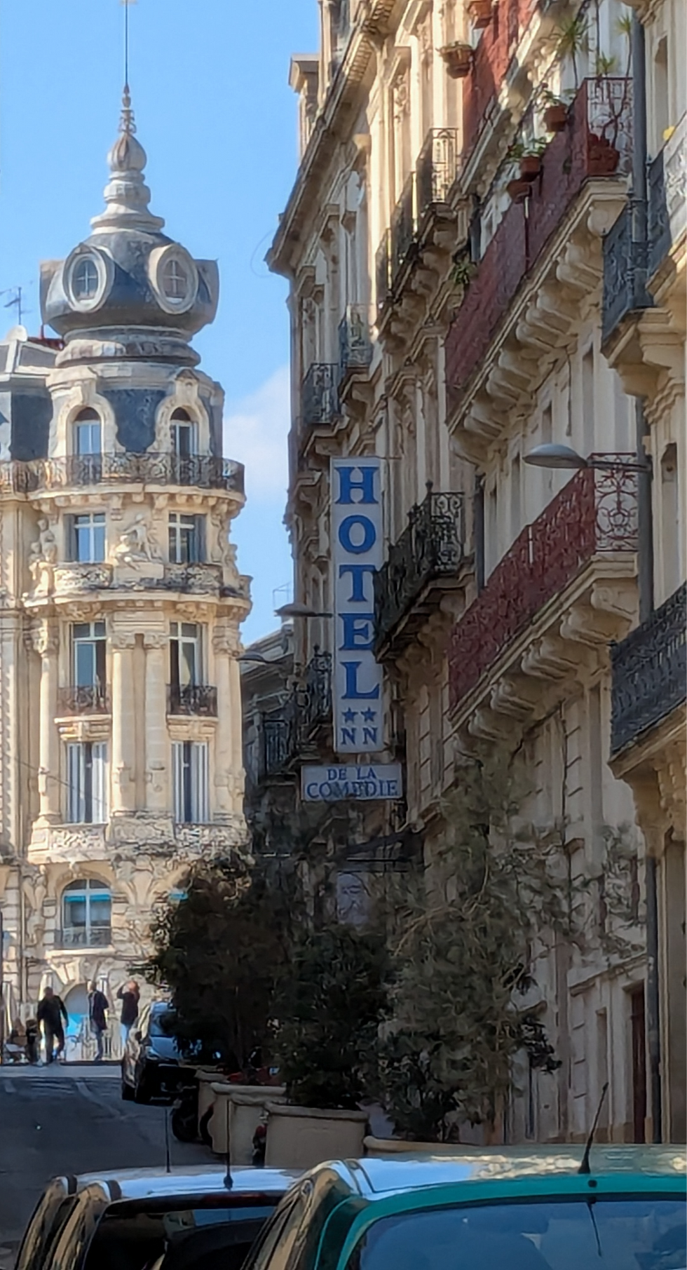 View down a narrow street lined with old French apartment buildings.