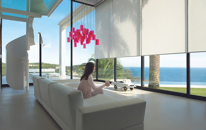 Lutron motorised white blinds in the luxury open plan living room.
