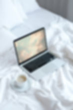 mockuuups-macbook-mockup-on-a-white-bed-with-coffee-on-a-saucer.jpeg