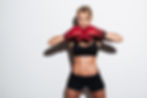 Portrait of a confident young athlete woman posing in boxing gloves isolated over white ba