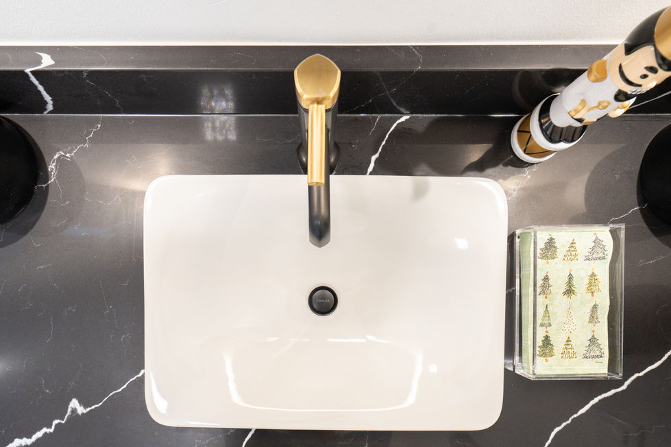 White rectangular sink with gold faucet, black countertop, Modern Bathroom Designs.