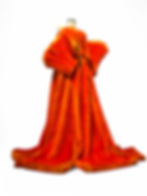 Orange faux fur couture skirt with extended train displayed on mannequin in studio.