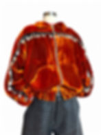 Orange velvet couture bomber jacket with silver coin embellishments displayed on mannequin in studio.