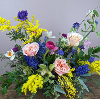 Spring compote vase withacacia, hyacinth, anemones, daffodils and roses.