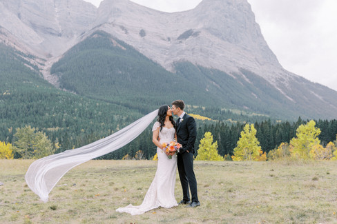 Bridal veil blowing in the wind while bride and groom kiss: Spray Lakes Mountain Elopement