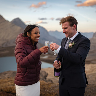 Couple sharing champagne during golden hour with Banff mountain views