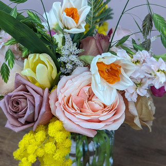 Acacia mimosa with garden roses, daffodils, tulips and other spring blooms to celebrate Spring Equinox