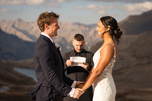 Couple exchanging wedding vows during their Banff helicopter elopement with mountain views